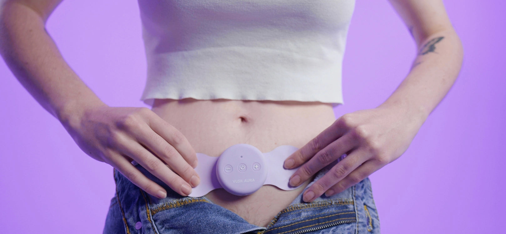 Close up of midriff with Aura pain relief device sitting on lower stomach